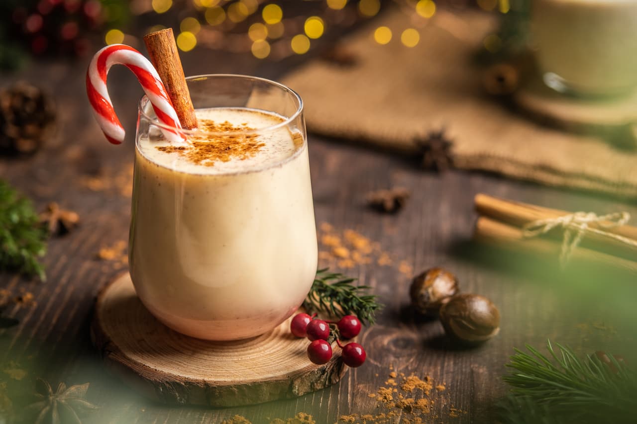Eggnog with spicy cinnamon.Christmas and winter holidays,Cozy cocktail with cinnamon and candy cane,Traditional Christmas drink with grated nutmeg and cinnamon,Homemade Holiday drink