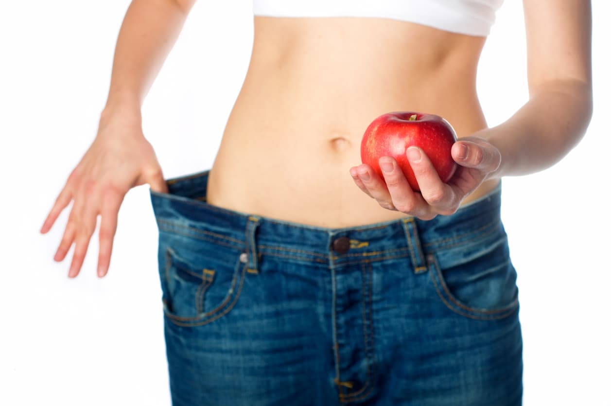 Slim woman holding apple in her hand