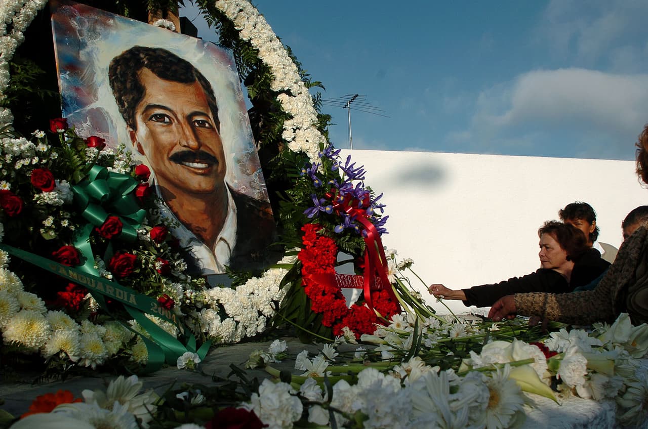 People place flowers at the base of a statue of Luis Donaldo Colosio during a ceremony marking the ten year anniversary of his assasination on Tuesday, March 23, 2004 in Tijuana, Mexico. Colosio was a Mexican presidential candidate who was shot at this spot while campaigning in 1994. The local PRI party used the moment as a campaign event for local candidates, and bused in about 1000 sympathizers for the ceremony. (AP Photo/David Maung)