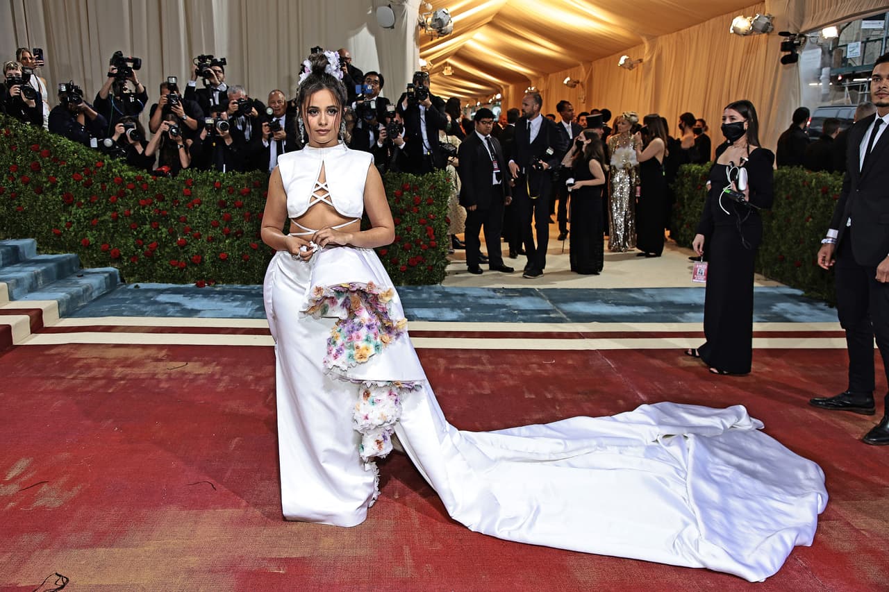 Camila Cabello: la cantante de origen cubano sorprendió con un top corto con cordones blancos, una amplia falda con detallesflorales en colores pastel y una cola de extraordinaria longitud. Su look fue del reconocido diseñador estadounidense, Prabal Gurung.