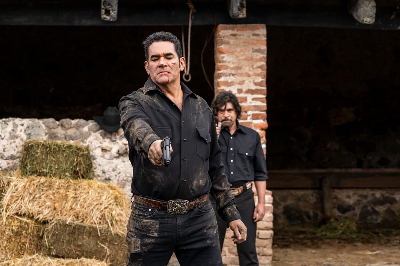 Cuando 'Octavio' va a disparar, 'Carmelo' le da un tiro por la espalda.