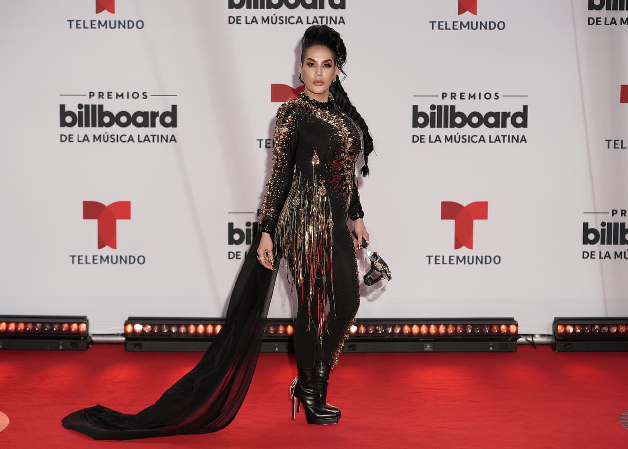 La cantante puertorriqueña Ivy Queen impactó con un conjunto negro con flecos dorados que acompañó con una capa.