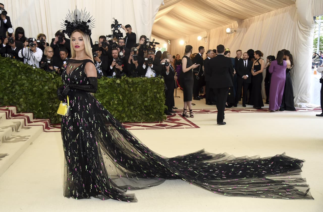 Con un vestido negro de Prada, muy original, portando corona, Rita Ora