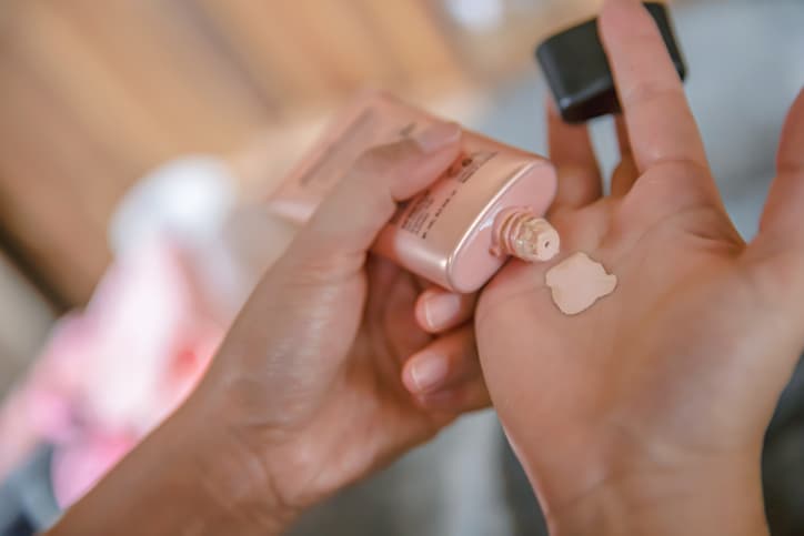 Cropped shot of unrecognizable Asian female hand matching foundation color on her palm of hand