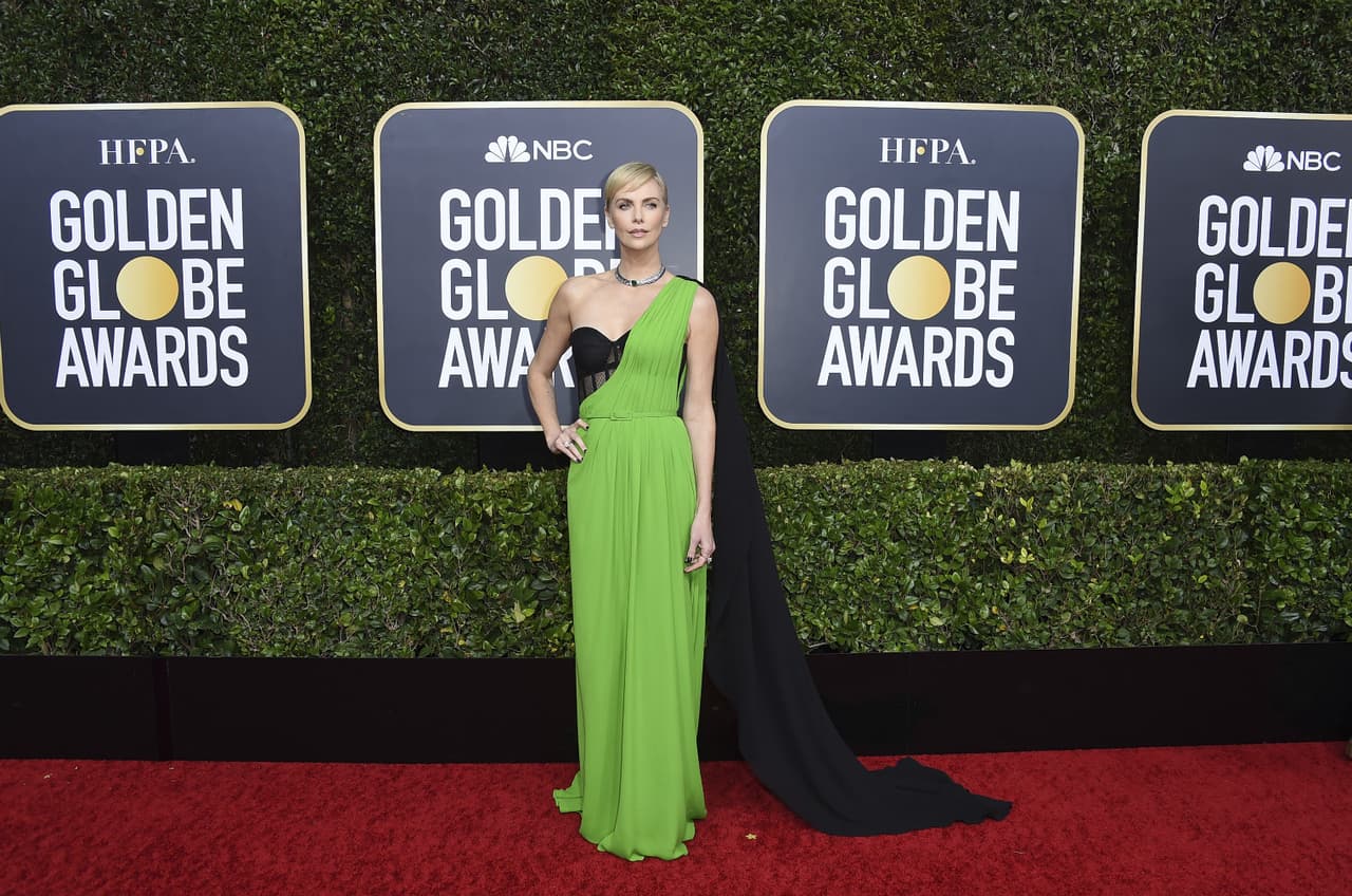 Charlize Theron optó por un diseño asimétrico de Dior en color verde con una capa negra.