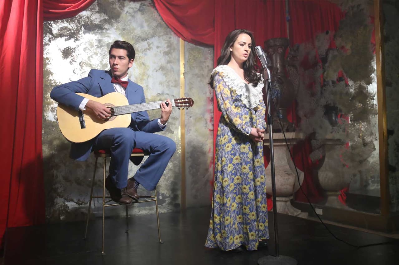 Lupita comienza a aceptar su destino como cantante y su padre la coloca a ella y a su hermano en el bar “El Farolito".