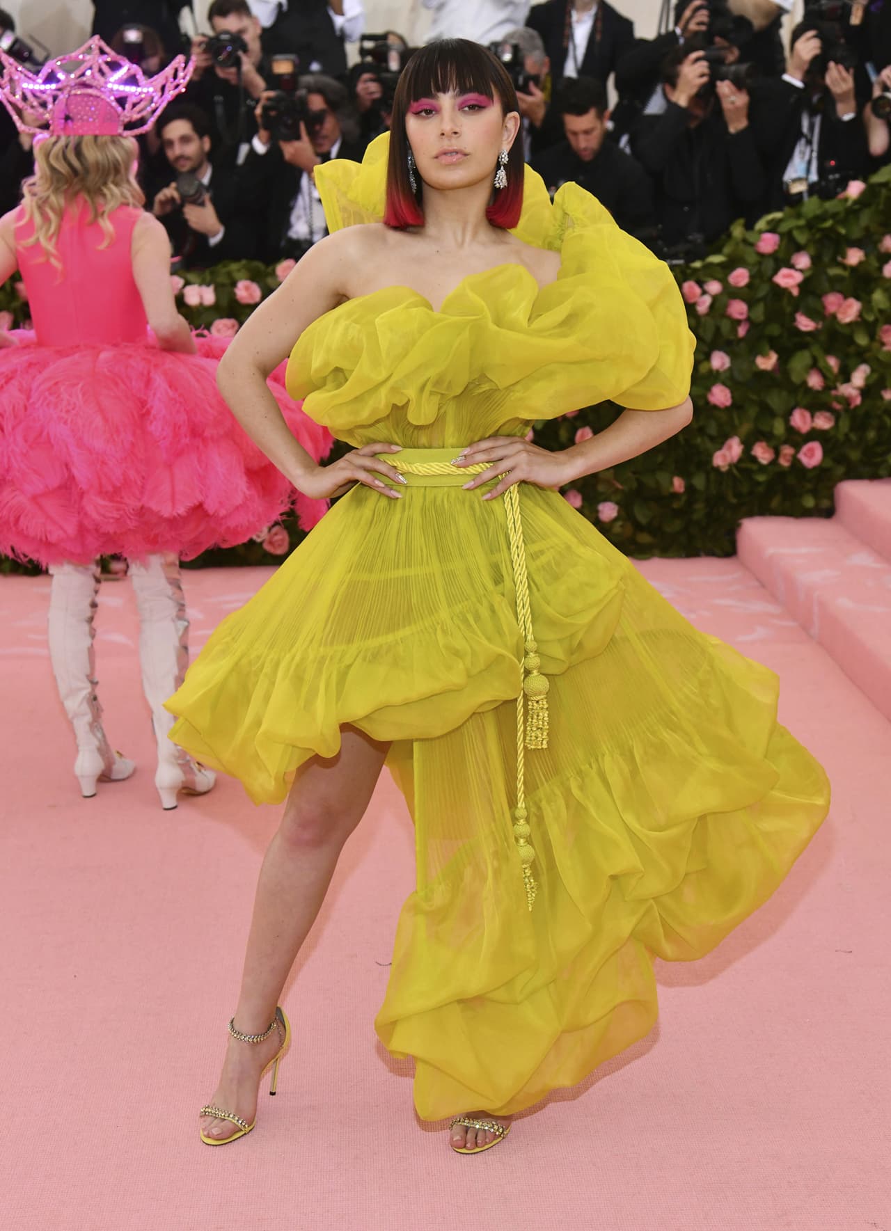 Charli XCX llegó al evento con un vestido asimetrico amarillo con transparencias.