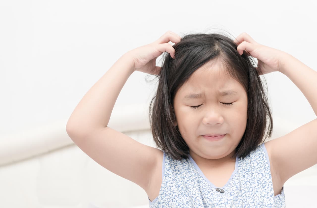 kid with freckles scratching his hair for head lice or allergies, Health care concept