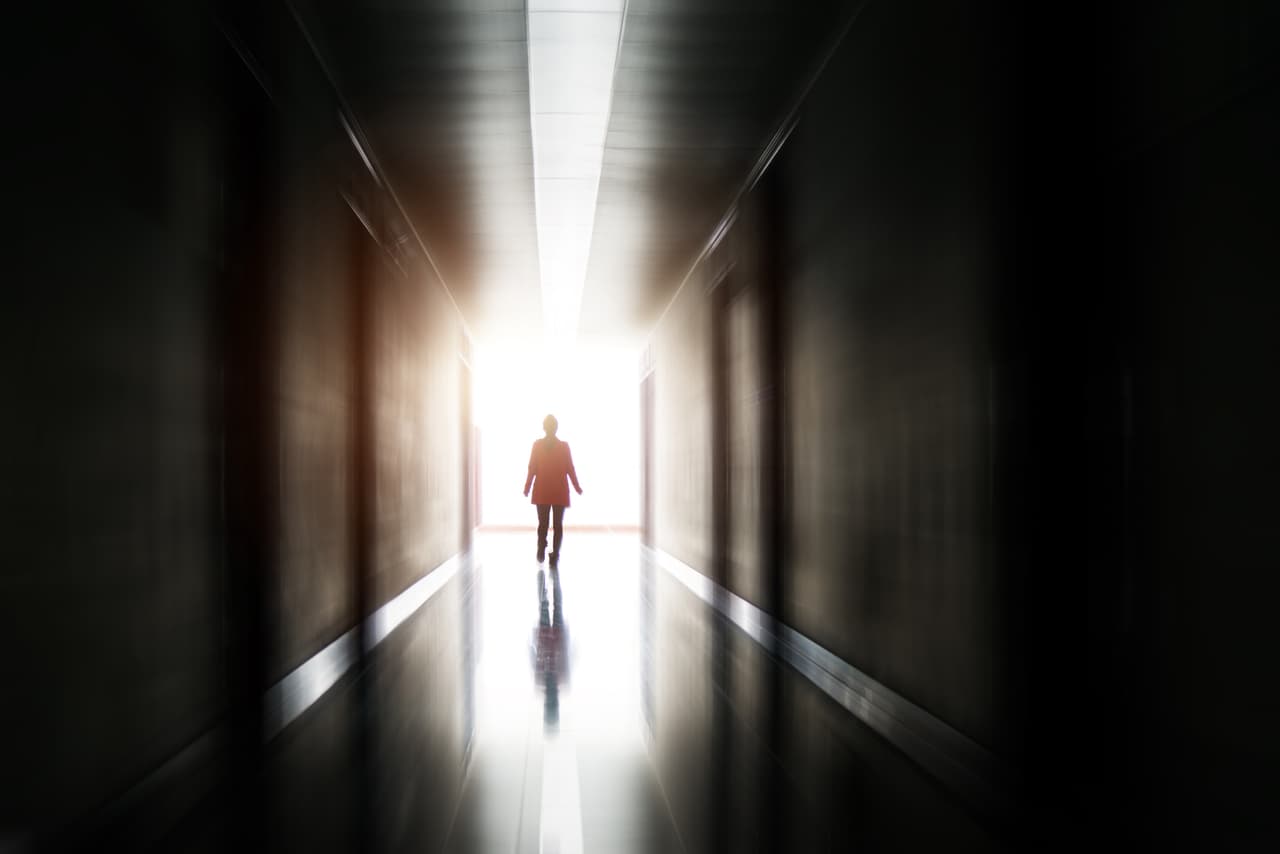Silhouette of a woman walking into the light