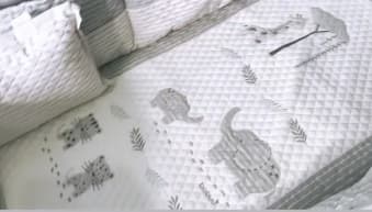 La ropa de cuna tiene bordadas figuras de animales y sobresale el color blanco con detalles en gris. "Este fue el que escogí yo, todo de leoncitos", se escucha describir a la estrella de televisión.