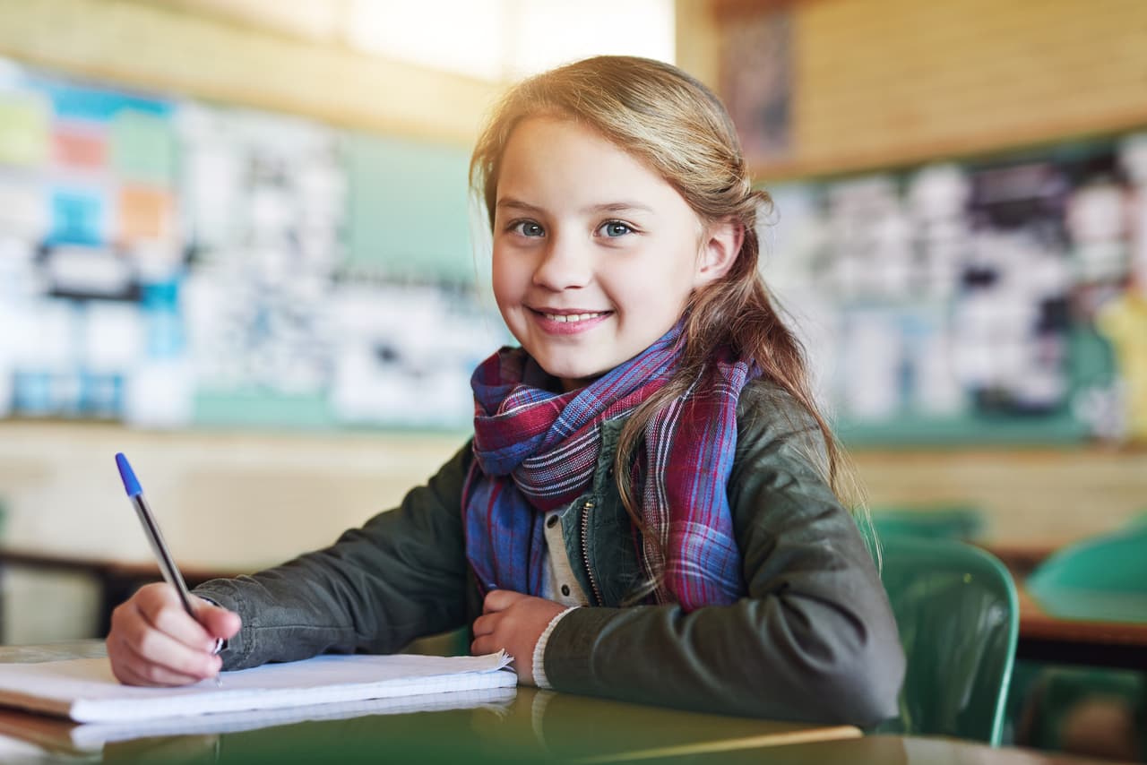 Shot of an adorable little girl doing her school work in class