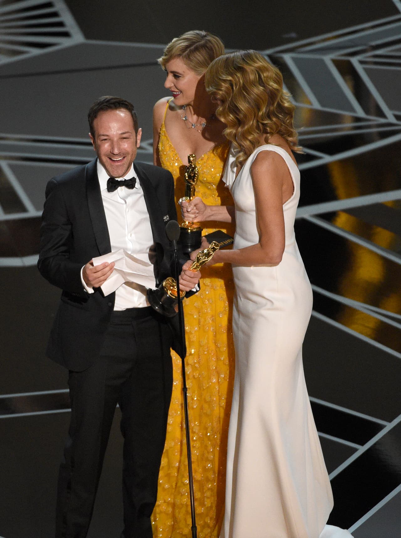 Laura Dern, from right, and Greta Gerwig present Bryan Fogel with the award for best documentary feature for "Icarus" at the Oscars on Sunday, March 4, 2018, at the Dolby Theatre in Los Angeles. (Photo by Chris Pizzello/Invision/AP)