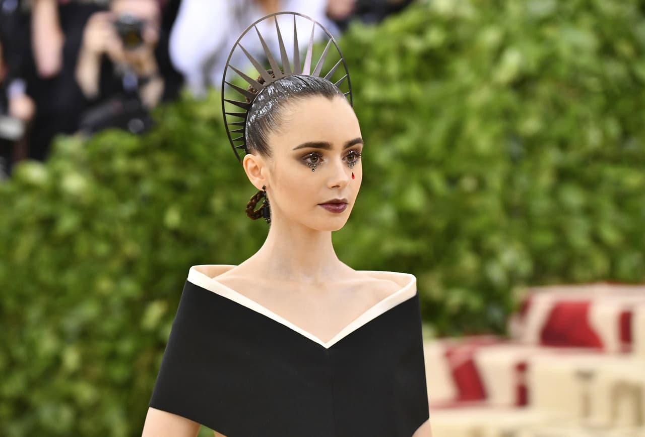 Con rosario en mano y una lágrima pintada en el rostro, Lily Collins llegó enfundada en un vestido de Givenchy