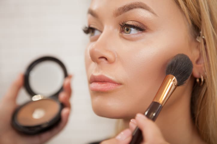 Close up of a beautiful woman getting glammed by professional makeup artist