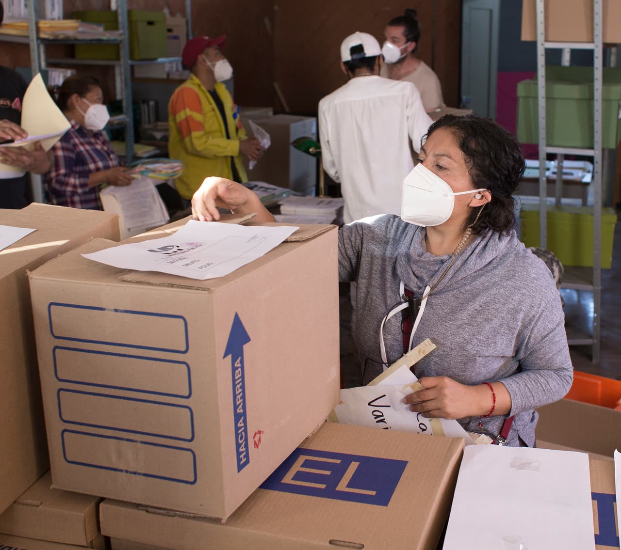 El equipo de producción alista todos los detalles para dejar acomodada la bodega con cajas y documentos que simulen la investigación.
