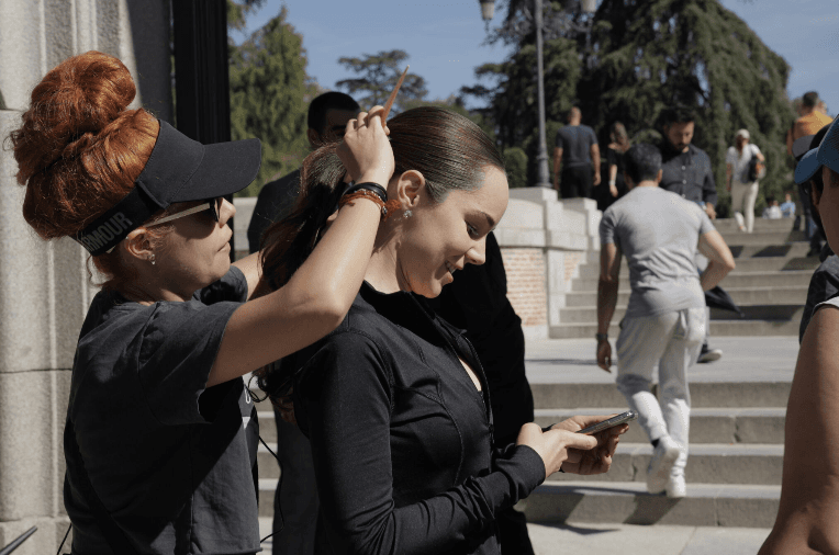 Y revisaba su celular mientras le daban los últimos retoques a su peinado.