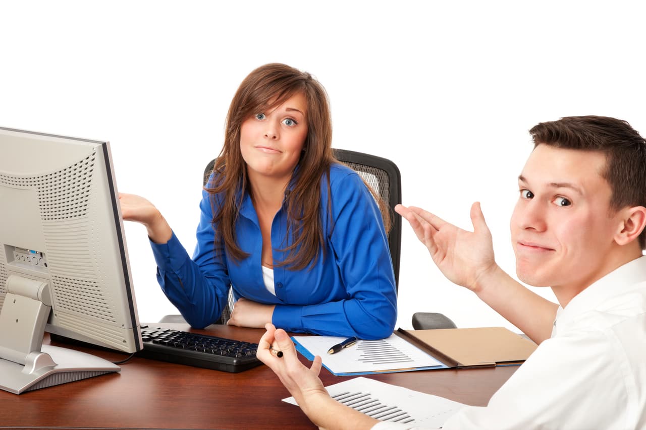 Photo of two business colleagues looking as if they're not sure what to say.