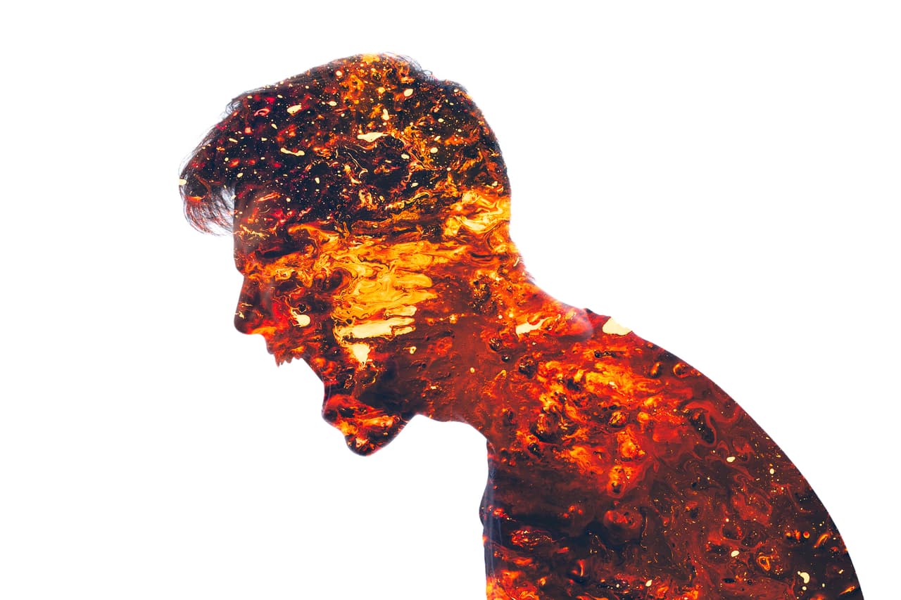 Mad scream. Angry man. Conflict person. Aggression neurosis. Double exposure of furious male silhouette coated in red hot lava isolated on white background.