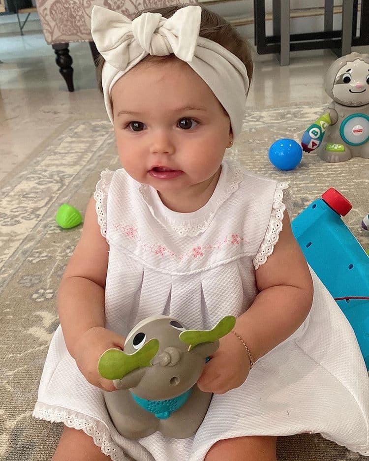En esta imagen se muestra a Martina divirtiéndose con un vestido blanco y una diadema del mismo tono que como detalle único tiene un maño.
