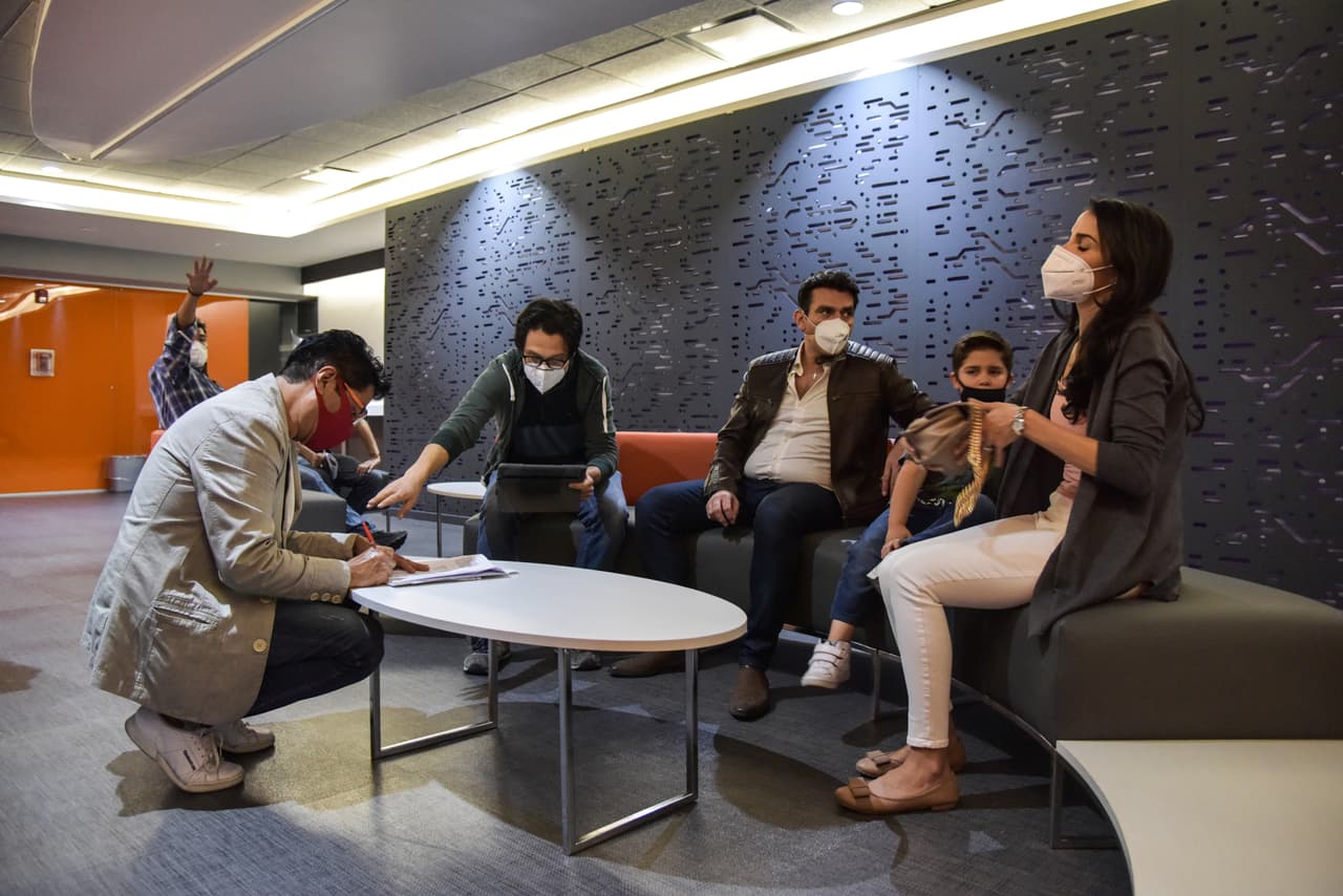 Jorge Salinas, Leo Herrera y Eva Cedeño, con las precauciones debidas ante la pandemia, ensayan la escena en la que la familia pasa un tiempo 'feliz' en el aeropuerto.
