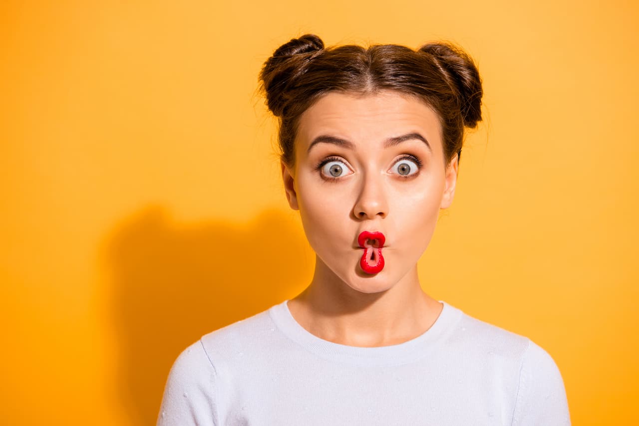 Close up photo beautiful she her lady pretty hairdo two buns big eyes fish-face foolish ridiculous hilarious idiotic facial expression wear casual white pullover clothes isolated yellow background.