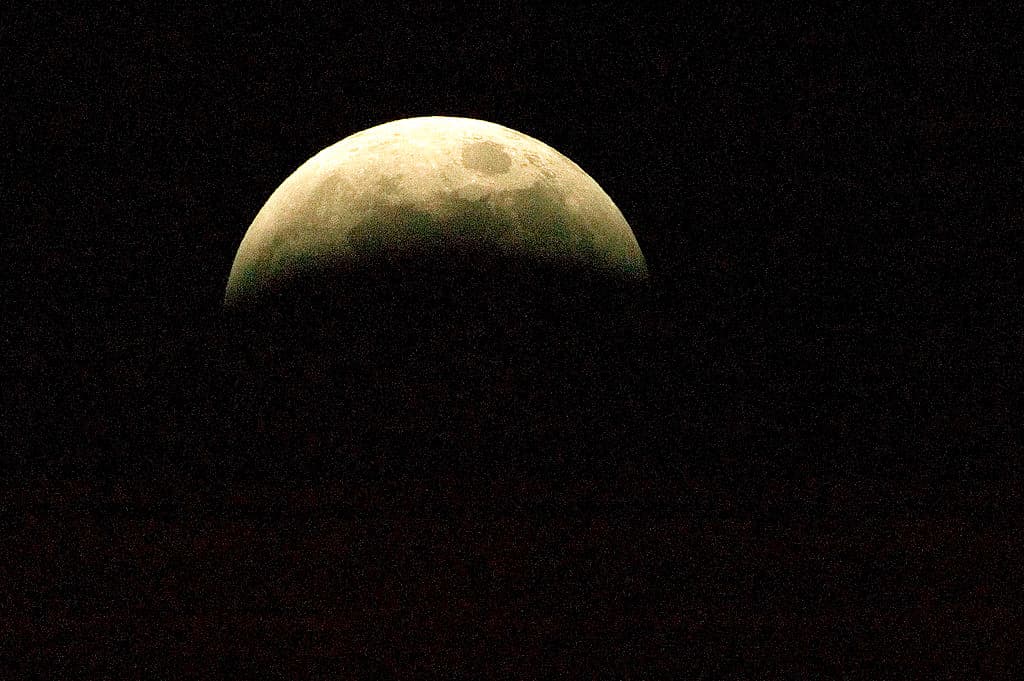 LONDON - MARCH 03: The earths shadow begns to engulf the moon during the total lunar eclipse on March 3, 2007 in London, England. For a little over an hour the earth passed between the sun and moon, casting a hue of red over it as the suns light is forced through the atmosphere. (Photo by Bruno Vincent/Getty Images)