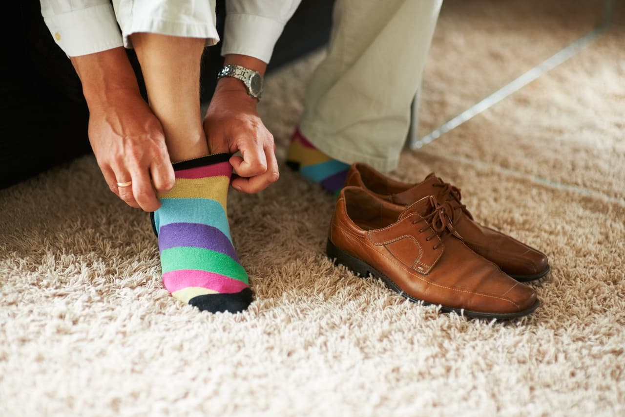 Man putting on colourful socks