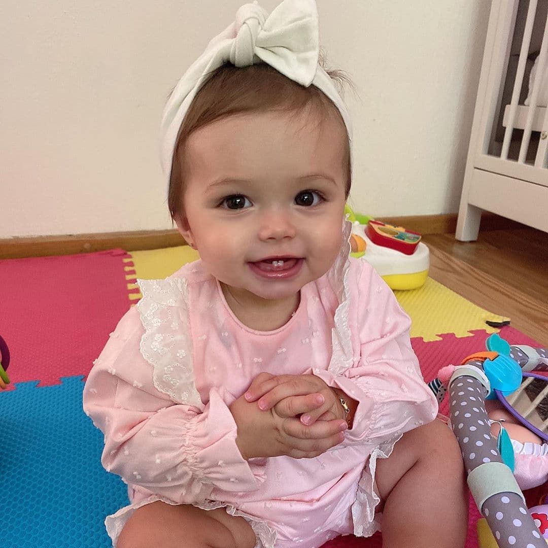 La pequeña muestra cómo los colores rosa y blanco son la mejor combinación en los mamelucos de bebé.