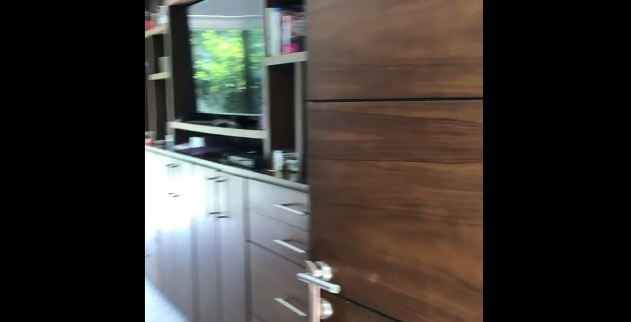 La decoración de su habitación es de muebles de madera, en los que se observa un centro de entretenimiento con una enorme televisión.