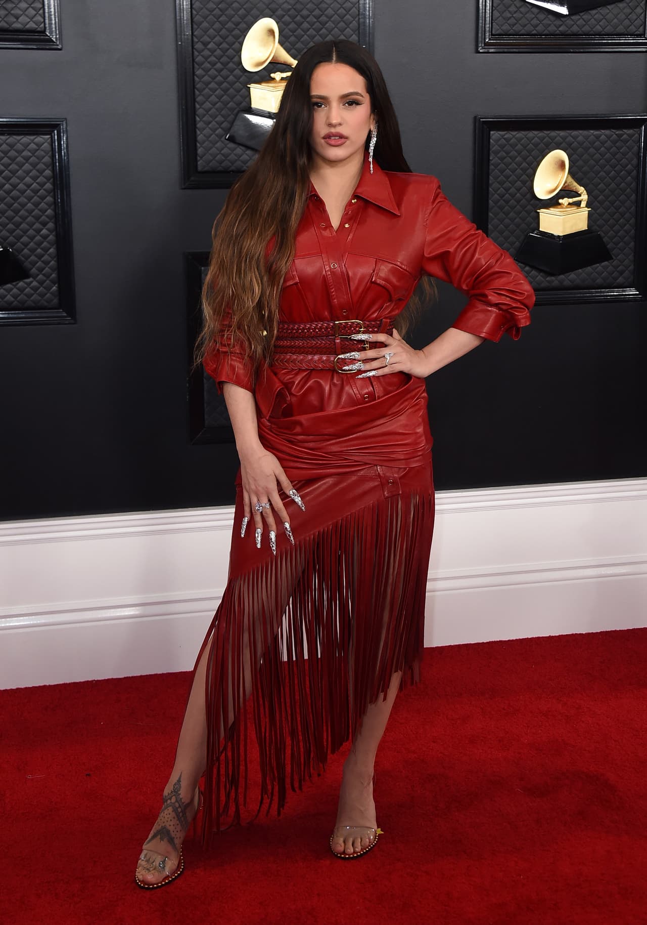 Con un outfit de cuero, Rosalía llegó a la alfombra roja. Su outfit es una creación del diseñador Alexander Wang. El modelo es asimétrico y con flequillos, todo en color rojo.