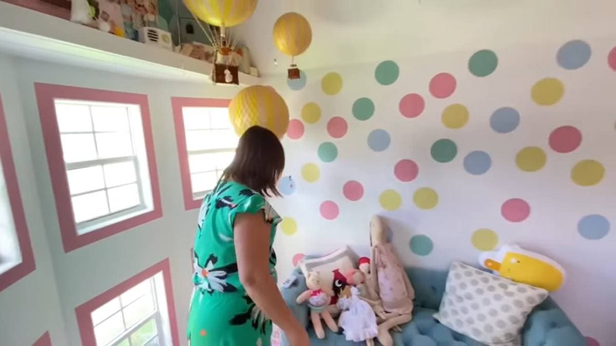 Además en la parte superior hay un juguetero y unos globos aerostáticos que cuelgan del techo; del otro lado se observa el aire acondicionado que tiene.
