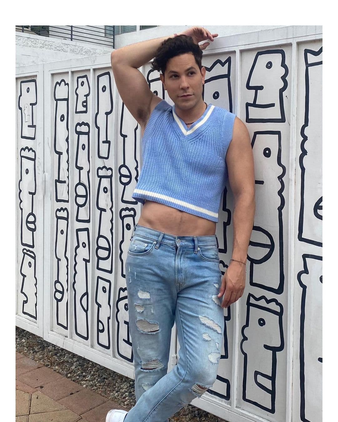 Deslumbrando las calles de Los Ángeles, nuestro querido Christian Chávez compartió esta foto en donde tiene uno de los mejores looks trendy-casual. La elección de prendas es simple pero correcta: jeans de mezclilla rotos, chaleco tejido azul con corte en V, tennis blancos y sí, ¡ese tremendo cuerpazo!