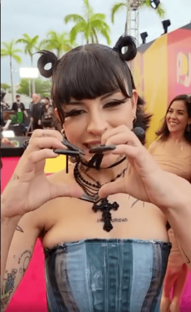 Cazzu: La argentina apareció en un atuendo de mezclilla de dos piezas del que resaltó su corset strapless en distintos tonos de azul. También, llevó sus clásicos collares y rosarios en color negro, y complementó con unas largas uñas de acrílico.