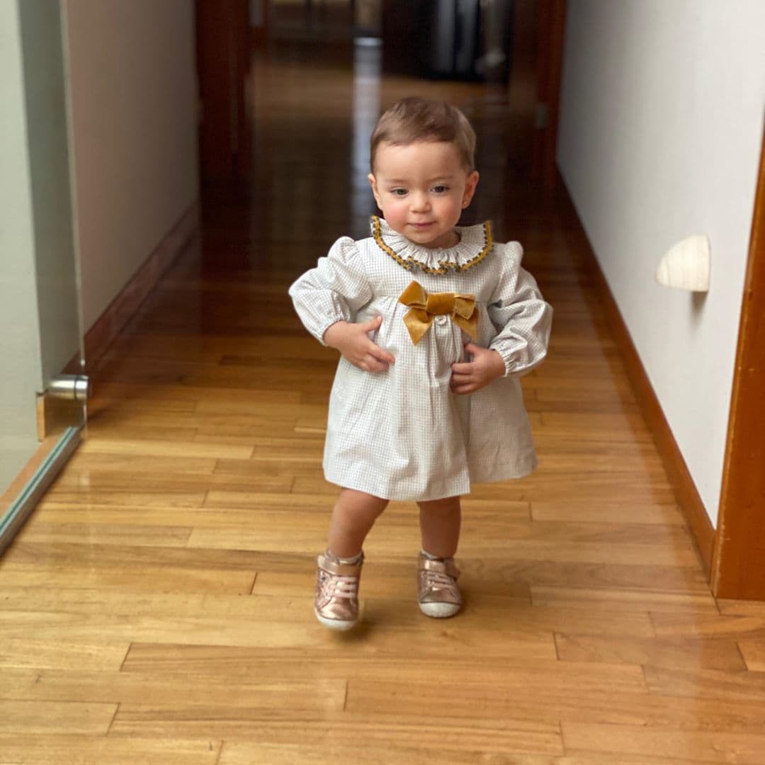 De acuerdo con las instantáneas, la pequeña, de un año, lució un vestido a cuadros con diseños en color café, el cual fue combinado con tenis en tono dorado.