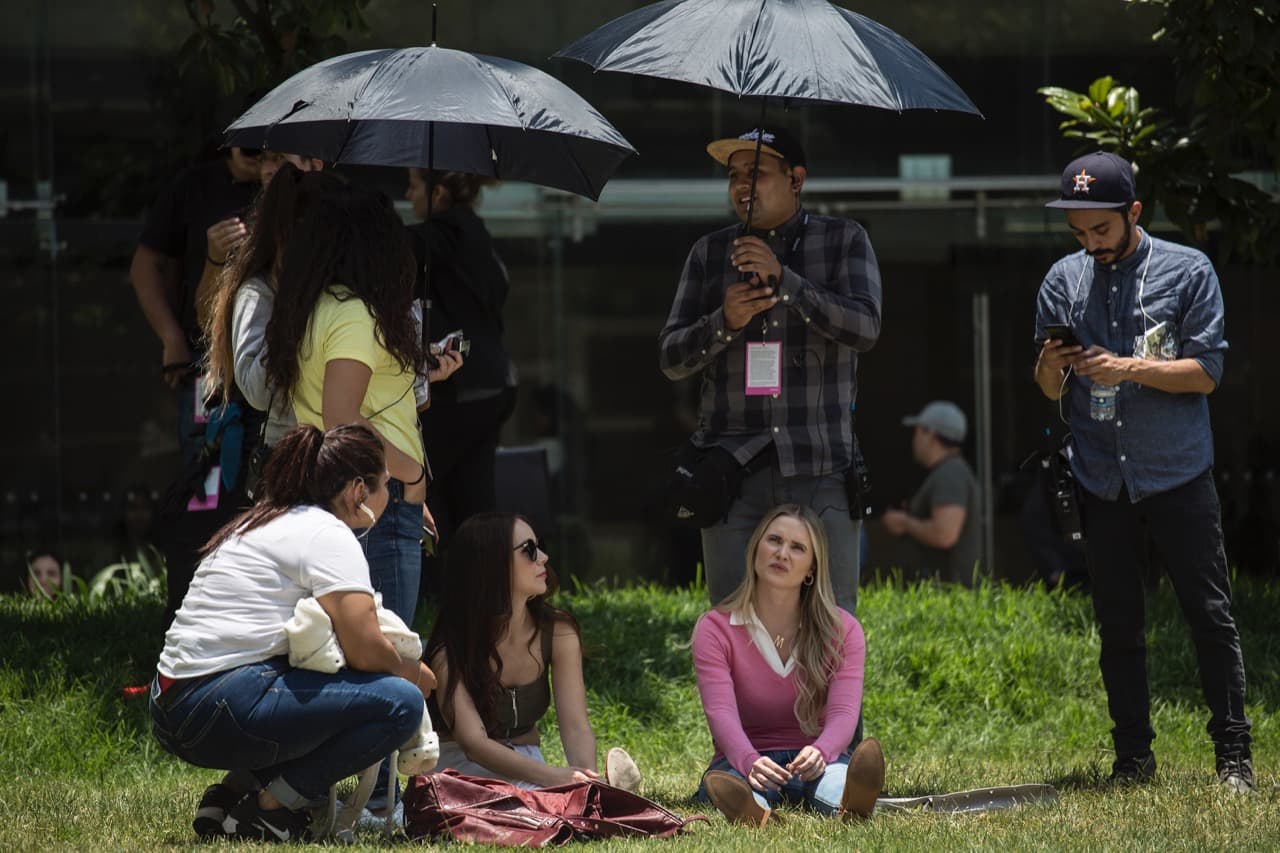 El equipo de producción protege a las actrices del sol en un ensayo. Ambas listas para grabar sus escenas.