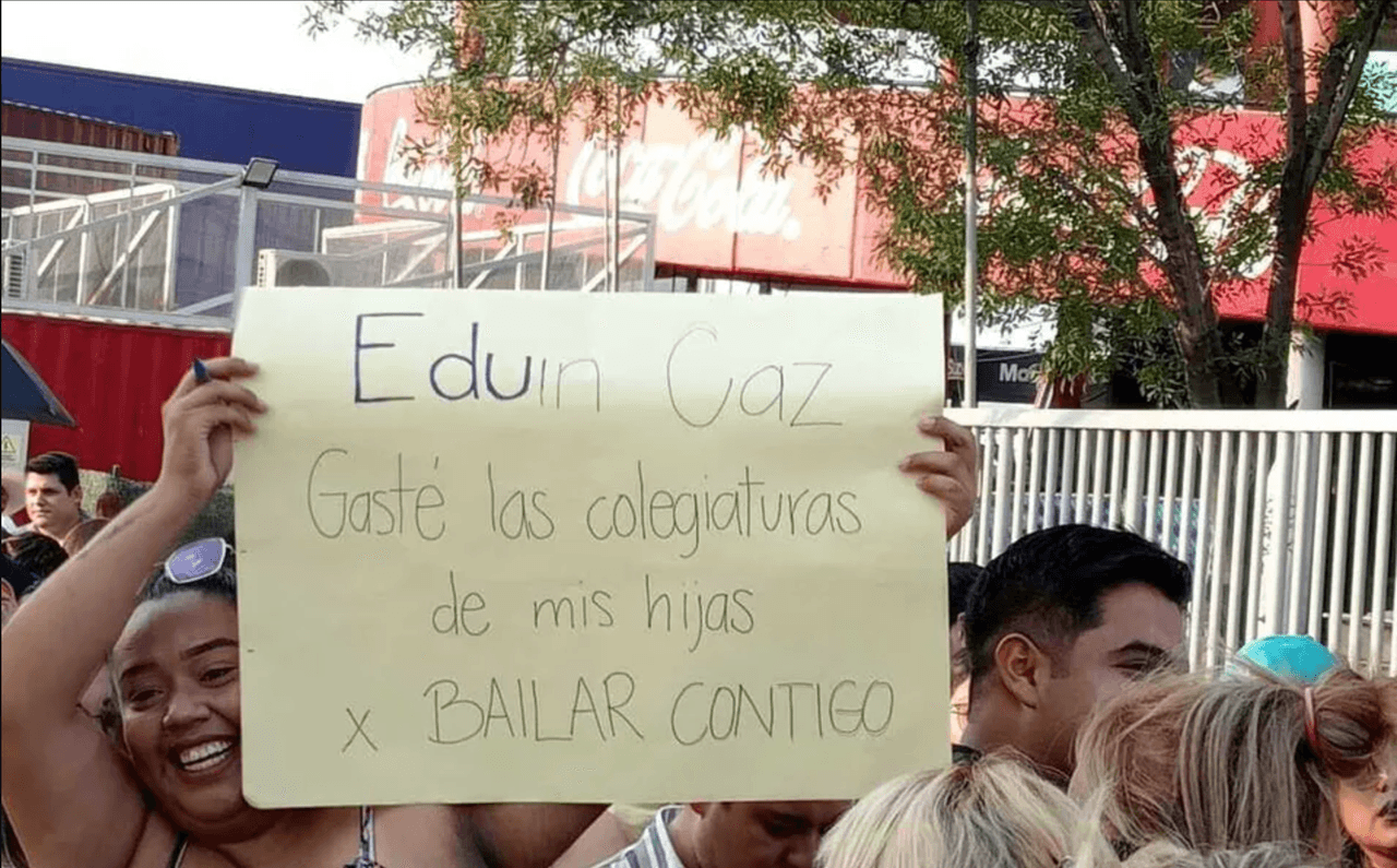 Mujer con cartel en el concierto de Grupo Firme