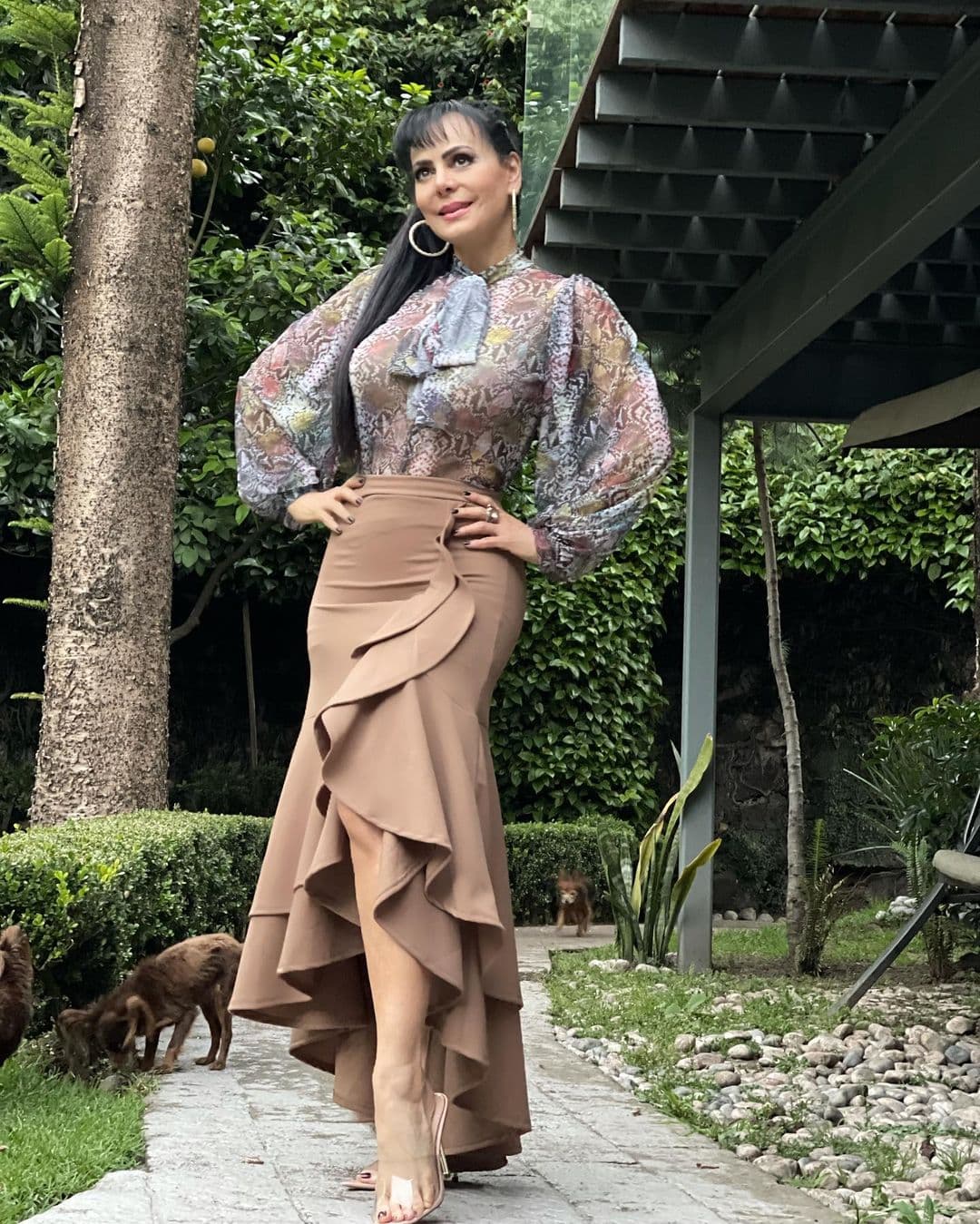 Pocos outfits gritan "estilo" de manera tan literal como el que aquí nos modela la guapa Maribel Guardia. Si lo que buscas es algo súper fashion y elegante, esta es tu mejor opción. Una blusa tipo camisa de manga larga con estampado y un moño, una falda semi-larga con olanes, aretes de aro y unos tacones color nude, es todo lo que necesitas para armar este gran outfit. La elección de colores es acertada, pero si quieres variar o no encuentras algo similar, vete por los colores oscuros como negro, gris o vino.