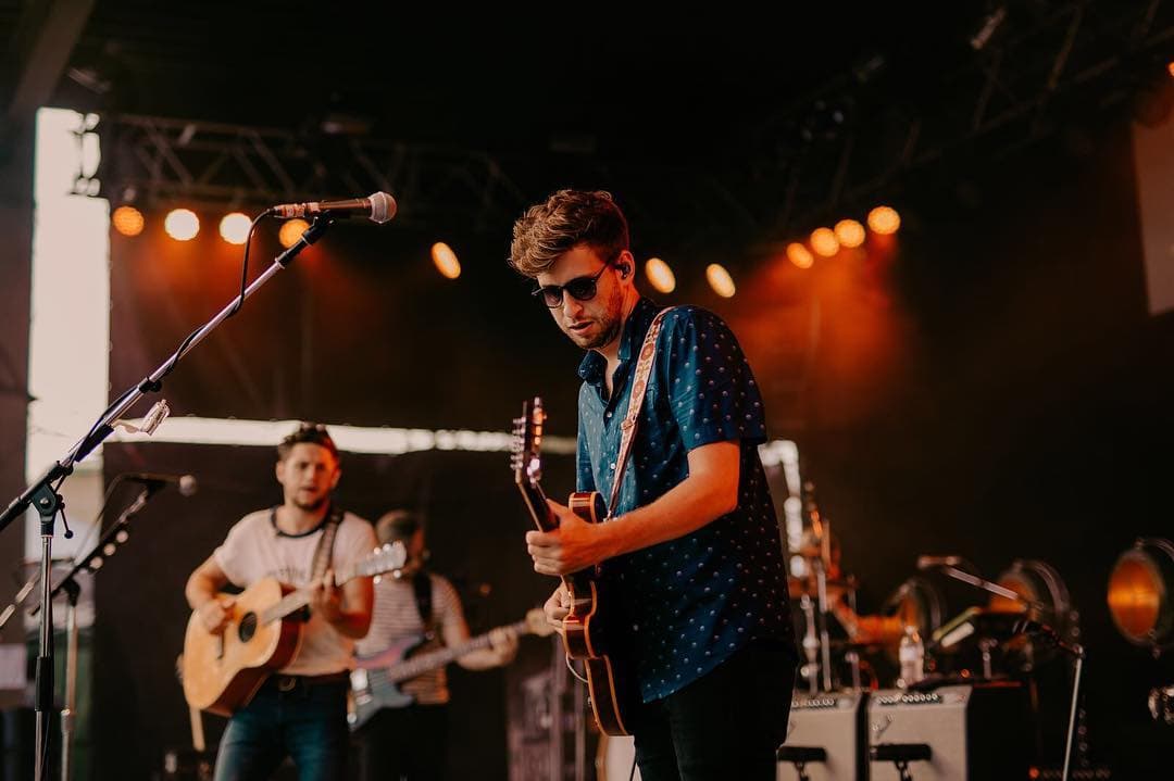 Niall Horan se apoya con otros músicos en el escenario.