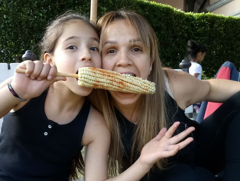 Siguiendo la tradición de Albertano, Andrea y su mamá degustaron un rico elote con chile.